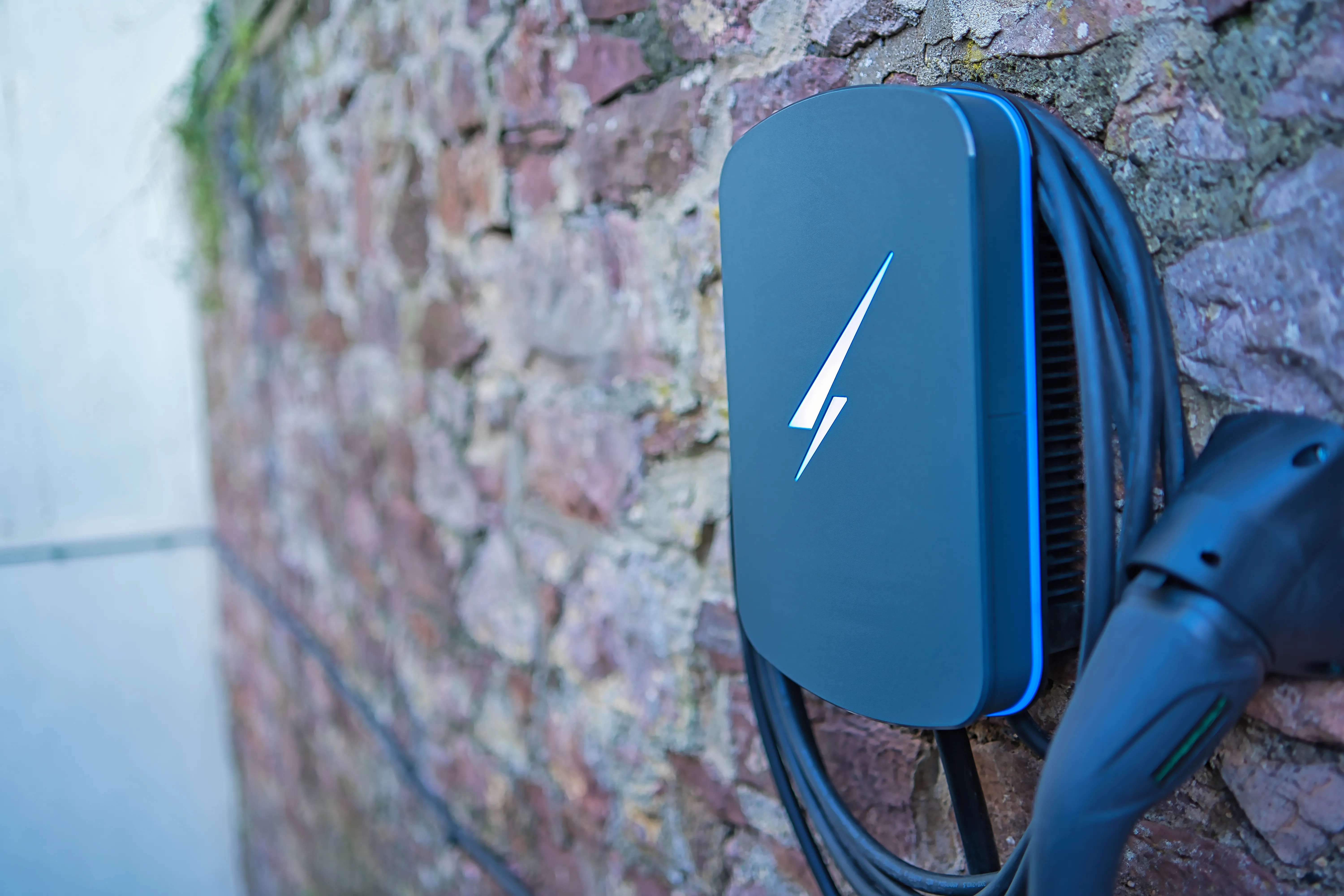 A charger attached to a brick wall with a lightning symbol on it.
